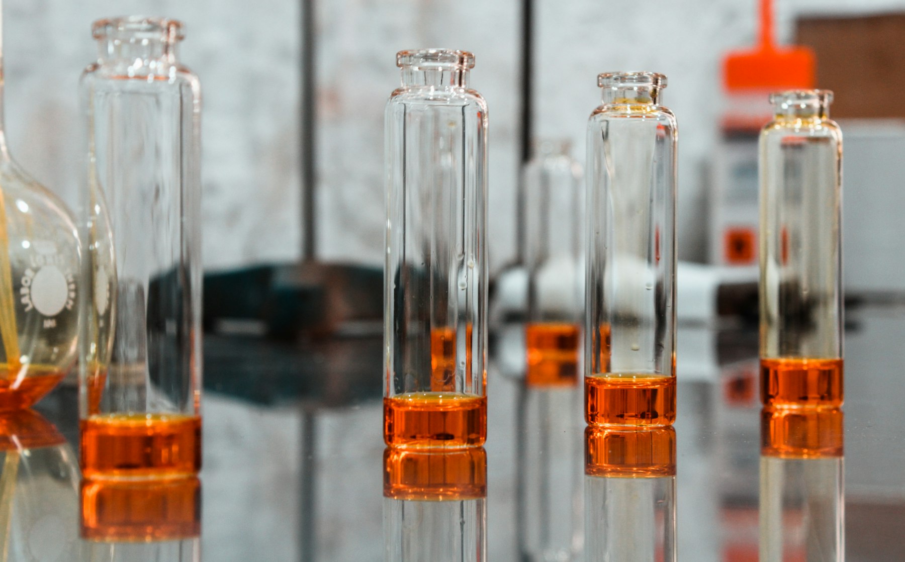 A row of clear chromatography vials holding amber solution
